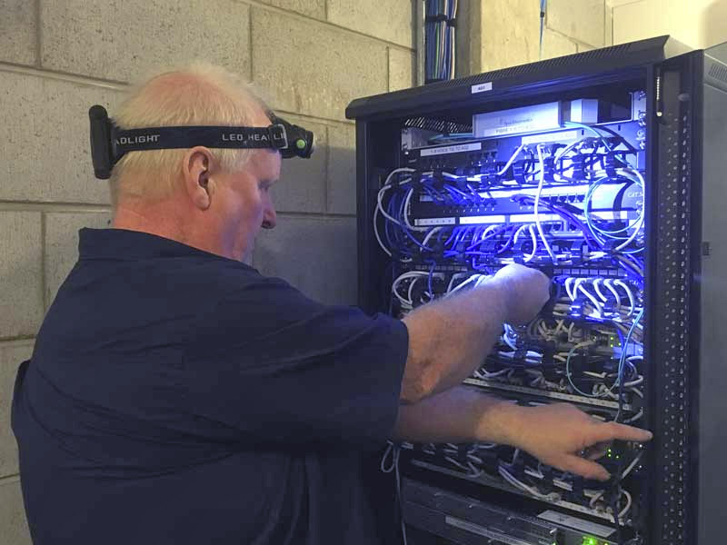 Technician servicing a network patch board