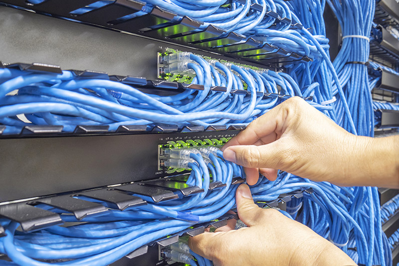 Technician installing network patch cables